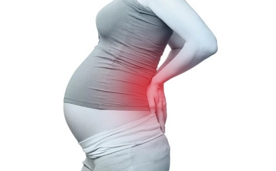تصویر سیاه و سفیدی که زنی را نشان میدهد که باردار میباشد و کمرش به شدت درد میکند