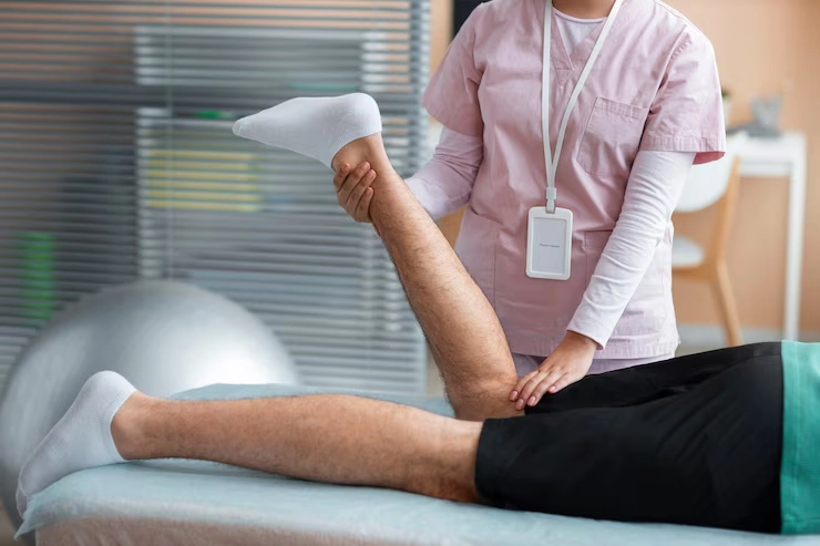 درمان پا درد از زانو به پایین - فیزیوتراپیست خانم در حال درمان زانوی بیمار 