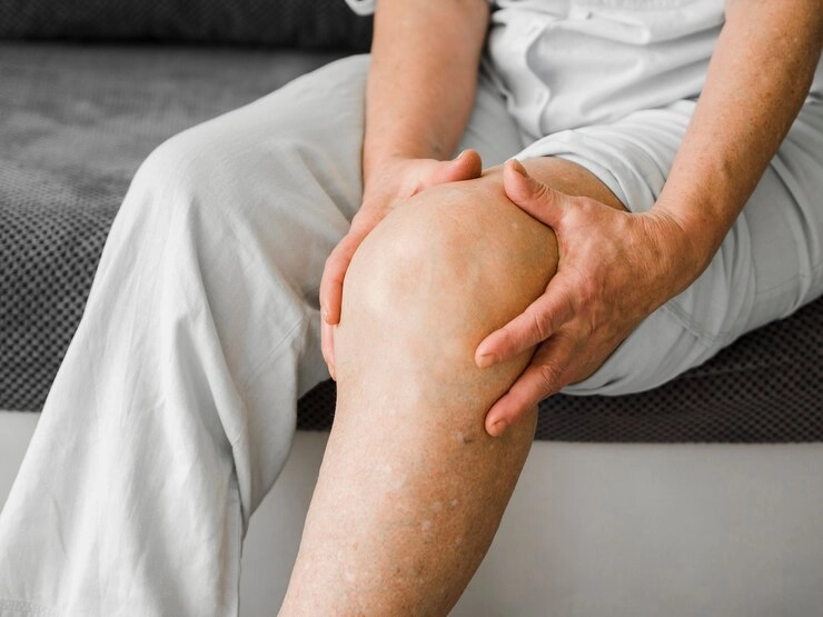 علت درد ران و ساق پا - مرد با درد زانو در حال گرفتن زانوها