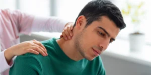 "مراجعه‌کننده در حال دریافت ماساژ درمانی برای بهبود علائم فیزیوتراپی گردن درد مزمن در کلینیک تخصصی"